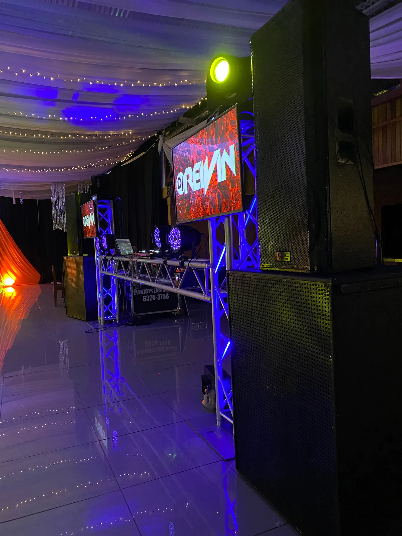 Setup DJ con pantalla LED y sonido profesional en salón decorado para celebración