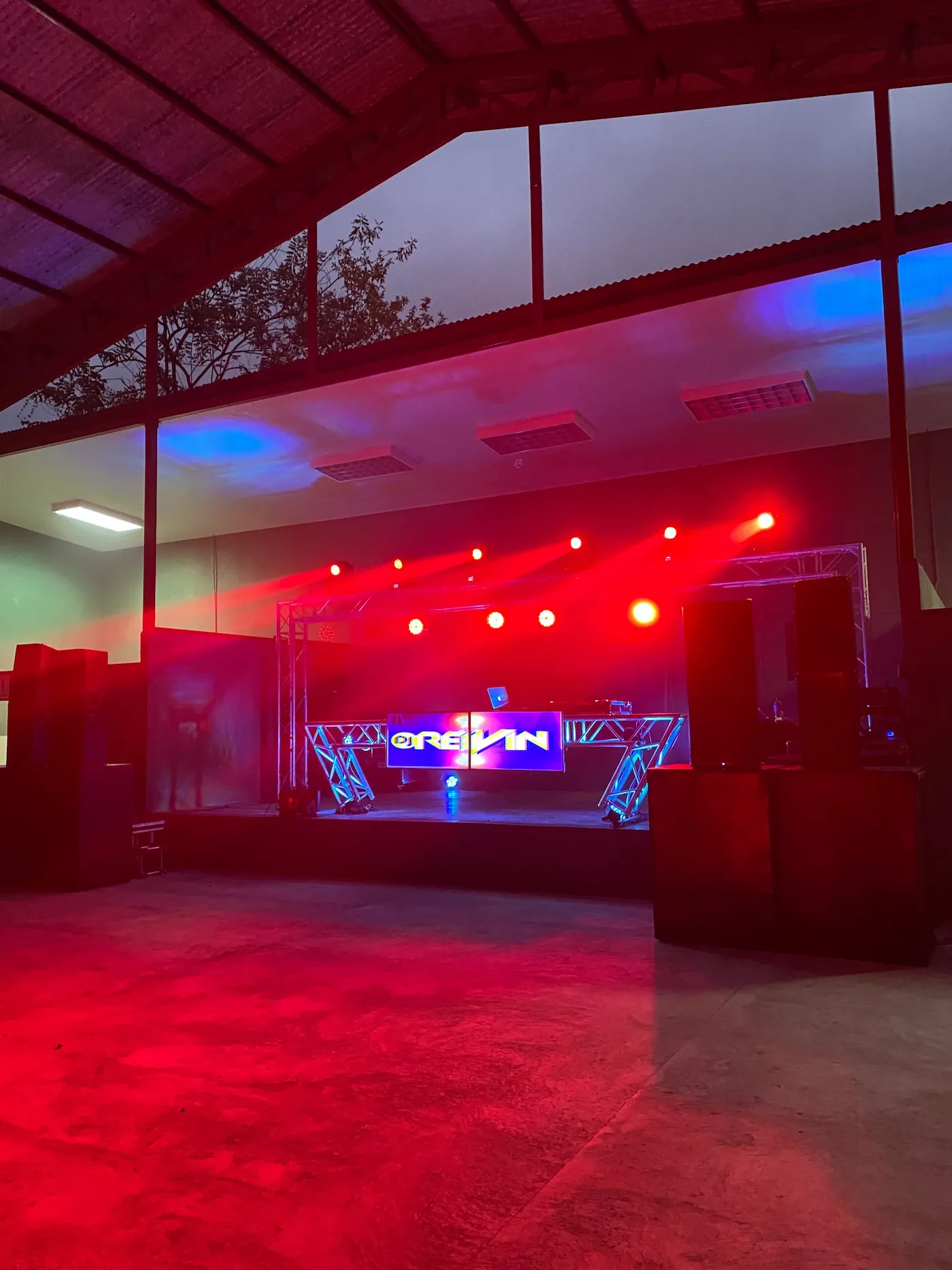 Setup de producción audiovisual con iluminación roja y pantalla LED en escenario