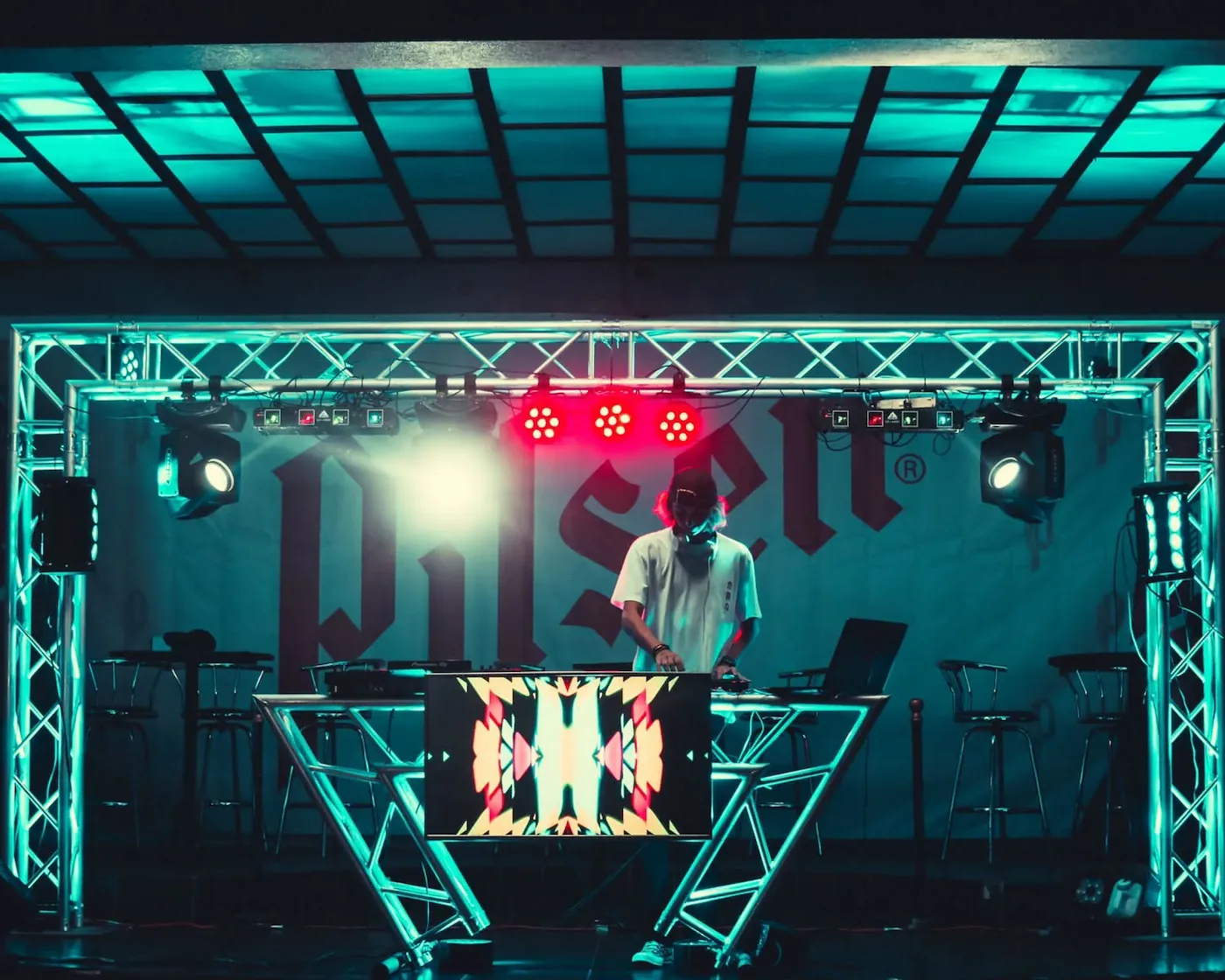 DJ profesional en escenario con estructura truss e iluminación beam, Eventos del Valle